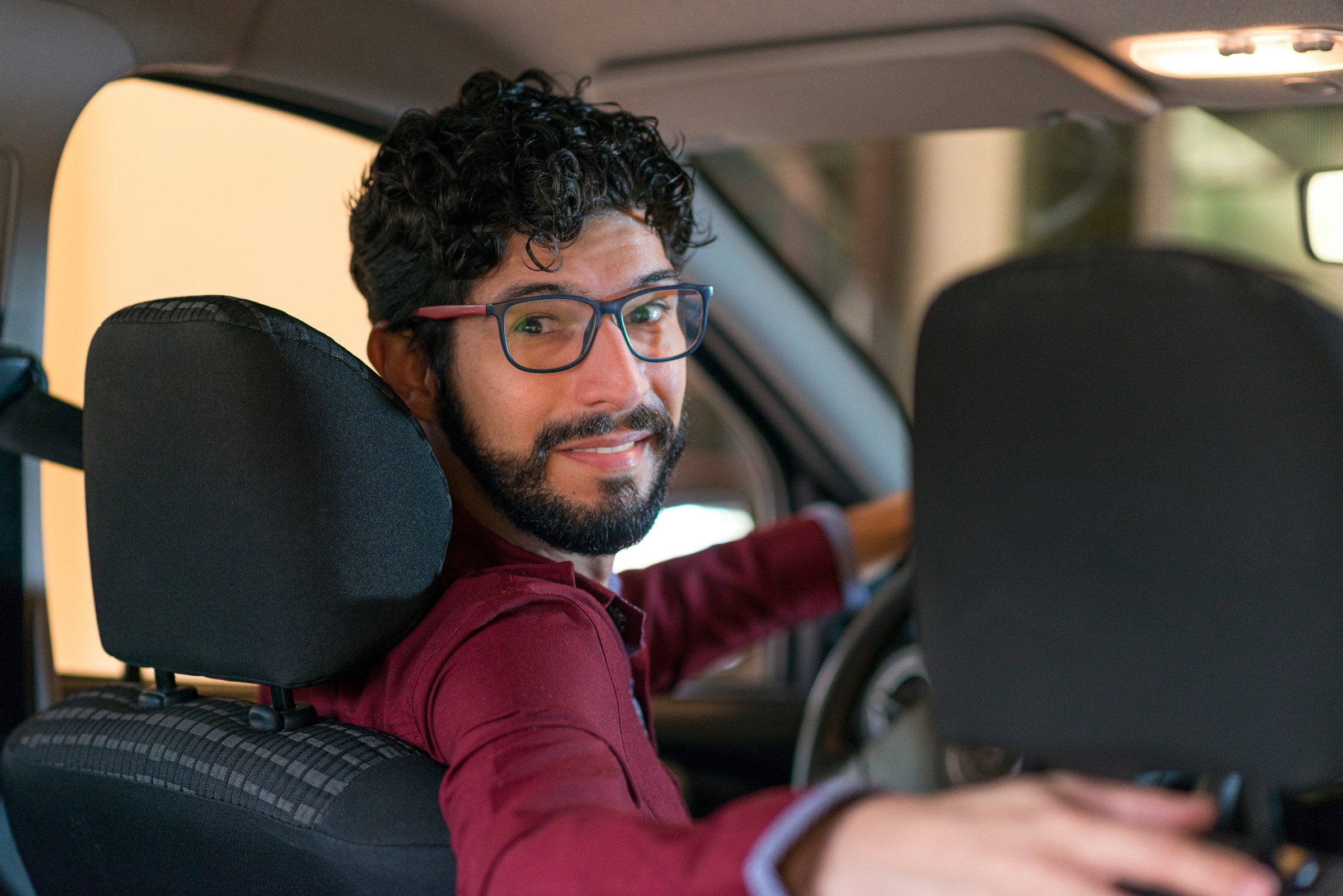 Smiling driver looking back from the driver's seat of a van